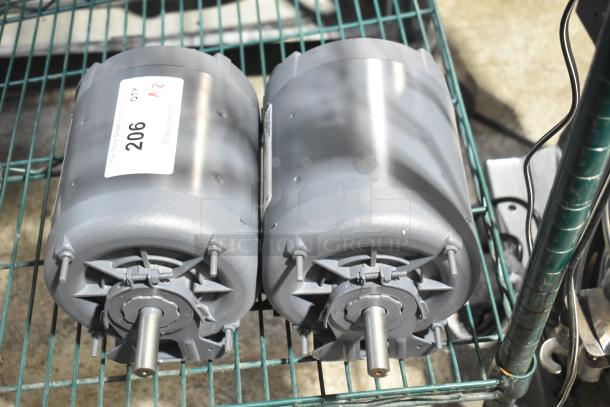Two industrial motors with visible metal shafts, labeled "QTY x2" on a tag. Excellent condition.