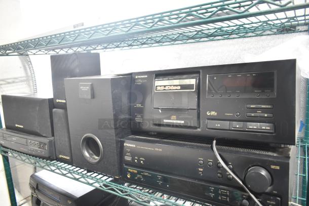 7 electronic items including Pioneer PD-F606 CD player, Pioneer VSX-305 receiver, Philco VHS player, and Pioneer speakers on a shelf.