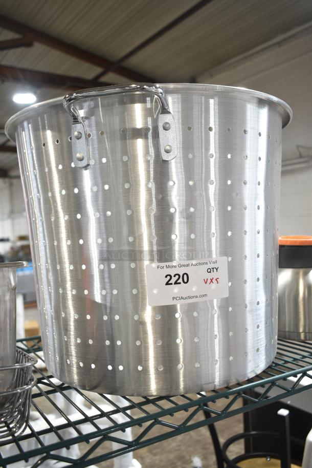 Large stainless steel colander with perforated design, brand new condition. Auction tag indicates Lot 220, quantity unknown.