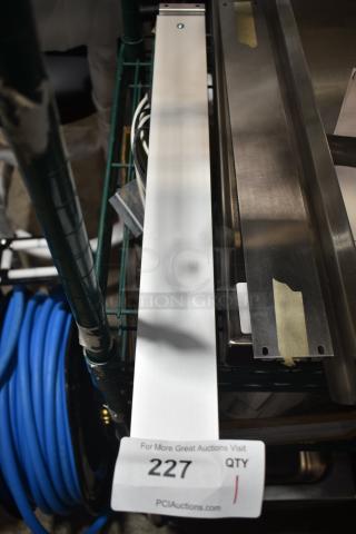 Brand new warming strip with minor scratches and dents, stainless steel, auction tag displaying "227 QTY 1" from PCIAuctions.com.