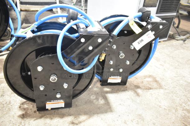 Brand new Regency powder-coated steel air hose reels, two units, minimal scratches, includes hoses, labeled with warnings and quantity tags.