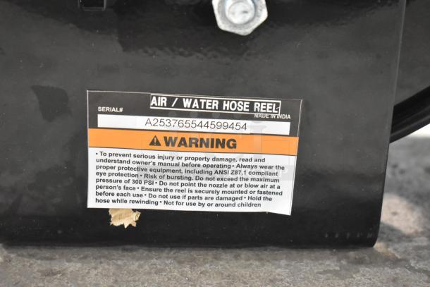 Brand new Regency powder-coated steel air hose reel with hose, serial# A253765544599454. Warning label visible.