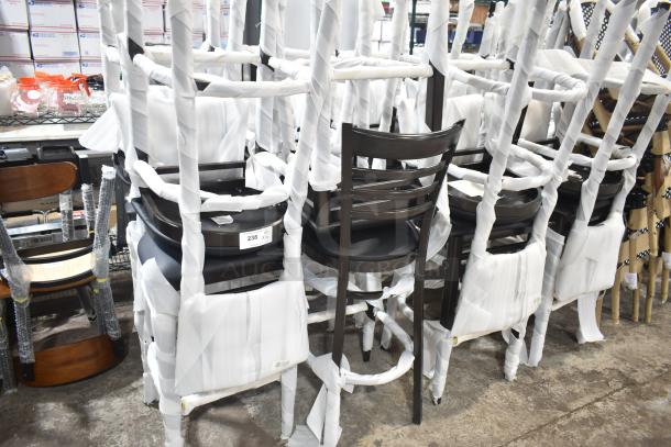 24 new Lancaster Spartan Metal Ladder Back Bar Stools, dark walnut finish, black vinyl seat, wrapped for protection.