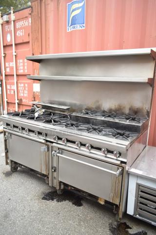 Commercial 12-burner gas range with 2 ovens, over shelf, and backsplash on casters; used condition, minor wear.