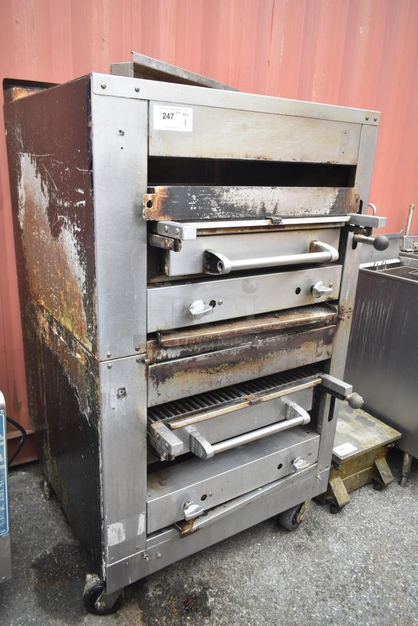 Commercial gas-powered vertical upright broiler on casters, stainless steel, visible wear and rust, labeled with item number.