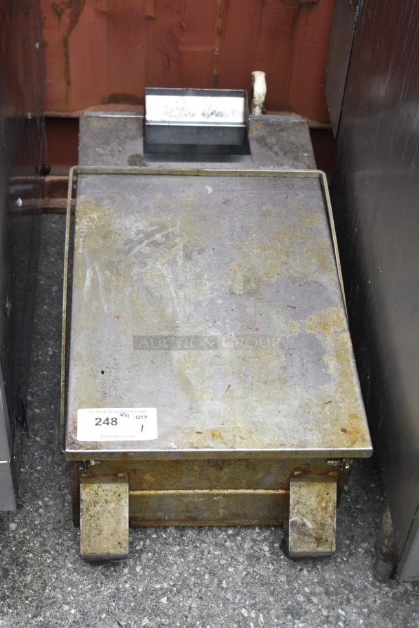 Commercial grease trap with rust and wear, metal construction, auction tag reading "248, QTY 1," for plumbing use.