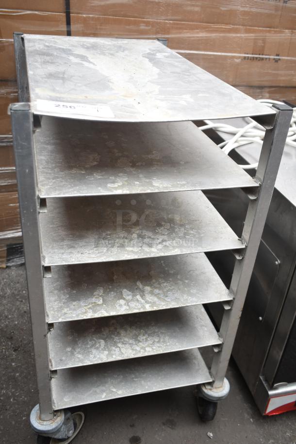 Commercial pan rack with six shelves on sturdy commercial casters; shows signs of wear and patina.