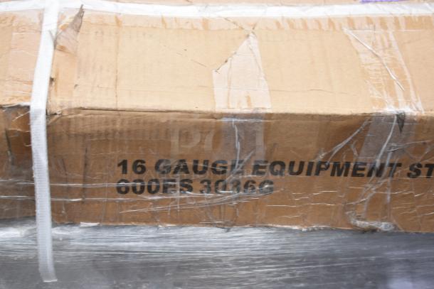 Cardboard box labeled "16 Gauge Equipment Stand 600ES 30360," wrapped in plastic with visible wear.