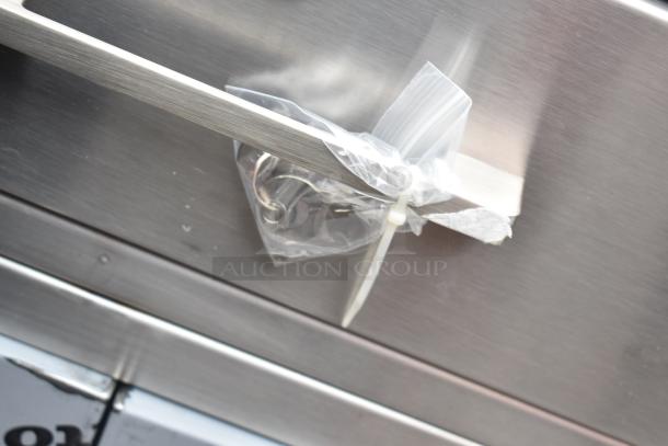 Brand new Lavex 257RD2523EBC mobile desk with scratch and dent damage, shown with keys in a plastic bag attached.