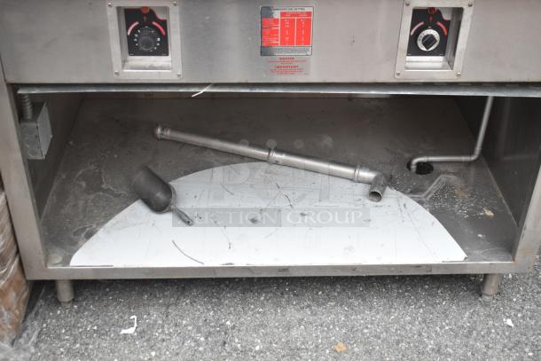 Commercial two-well steam table with under shelf, stainless steel, used condition, features dials and piping.