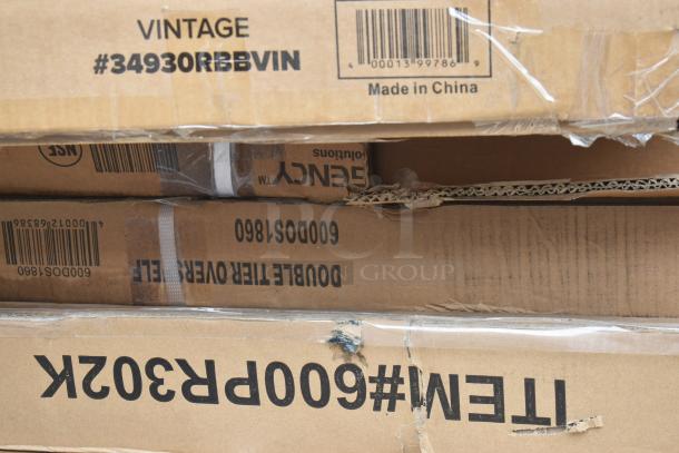Cardboard boxes with labels including "Vintage #34930RBBVIN," "Double Tier Overshelf," and "ITEM#600PR302K." Items are new, scratch and dent condition.