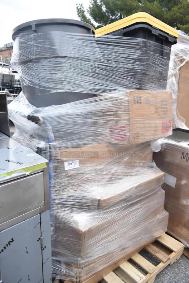 Pallet of brand new scratch and dent items, including work tables and storage totes, wrapped in plastic with visible labels.