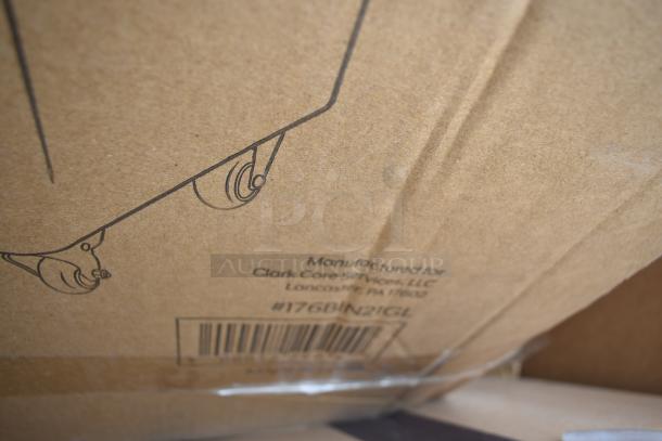 Cardboard box showing wheels illustration and label for Clark Core Services, Lancaster, PA. Contains assorted scratch and dent items.