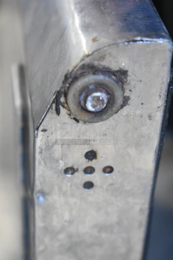 Close-up of a metal component with visible rust and drill holes, part of the Turbo Air MST-72 Sandwich Prep Table.