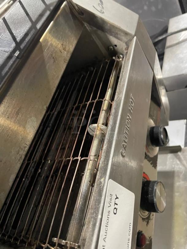 Hatco Toast-Qwik TQ20BA stainless steel conveyor toaster, 208V, shows wear, on legs, caution hot label visible.