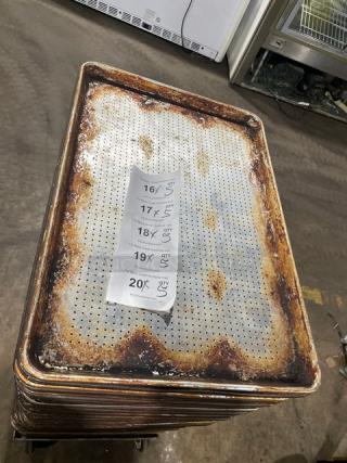Commercial perforated sheet pan stack with visible wear. Includes tag showing multiplier options for bid.