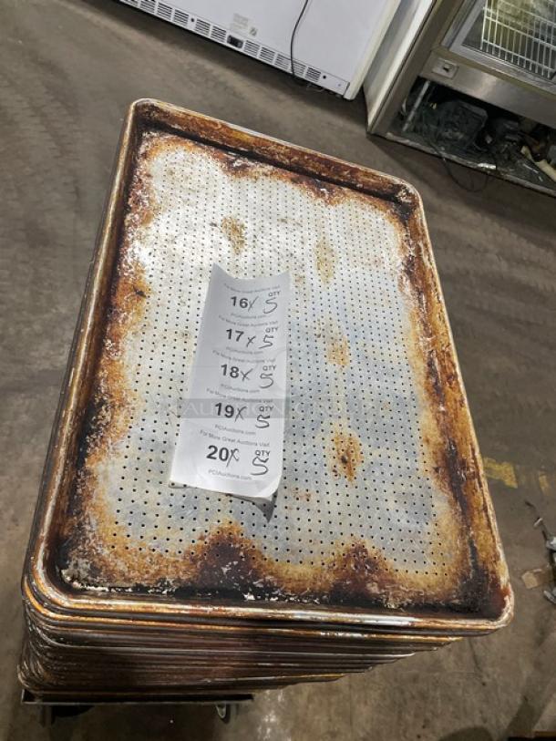 Commercial perforated sheet pan, well-used condition, rust and wear visible, stack of pans. Tag shows bidding multiplier.