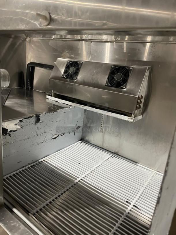 CoolTech CMPH60BM stainless prep table with 2 doors, poly coated rack, and refrigeration unit. Good condition, on casters.