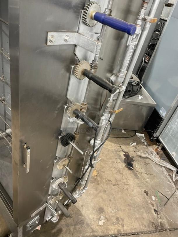 Attias stainless steel gas rotisserie cabinet, full-height, on casters, with visible gear mechanism and handles, used condition.