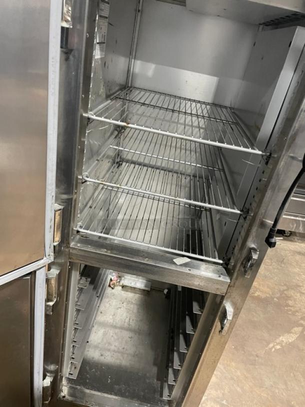 Traulsen AHT132DUTHHS commercial stainless steel reach-in refrigerator with solid half door, wired racks, and casters.