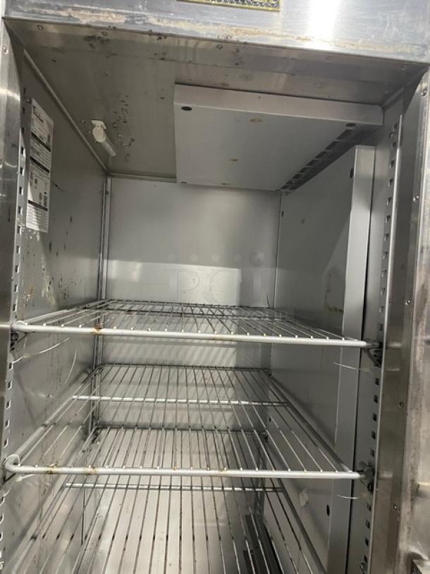 Traulsen AHT132DUT-HHS commercial stainless steel refrigerator, single section, half door, with wired racks, on casters.