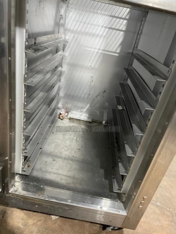 Traulsen stainless steel single section reach-in refrigerator, model AHT132DUT-HHS, with wired racks and casters.