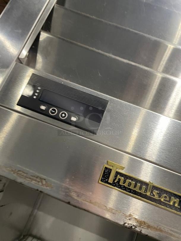 Traulsen commercial stainless steel half-door refrigerator, model AHT132DUT-HHS. Features wired racks, digital controls, and Traulsen logo. 115V, 1 phase, on casters. Serial number 22K03632.