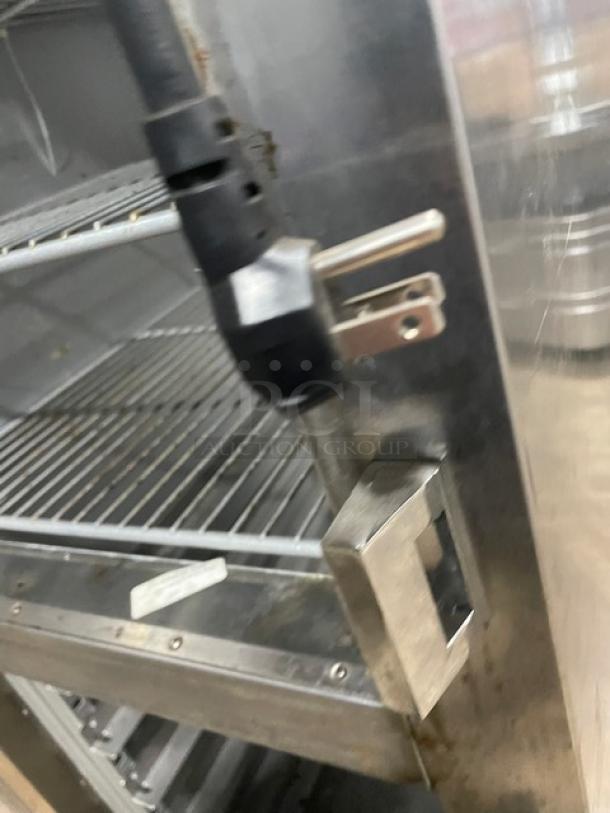 Traulsen stainless steel half door refrigerator, model AHT132DUTHHS, with wired racks and casters, shown open.