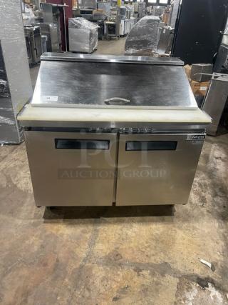 Dukers DSP48 stainless steel two-door refrigerated prep table with cutting board, poly-coated rack, on casters.