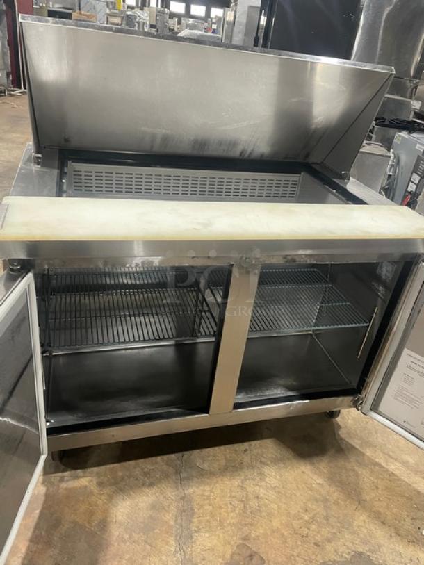 Dukers DSP48 stainless steel 2-door refrigerated prep table, bain-marie style, with cutting board, poly coated rack, on casters.