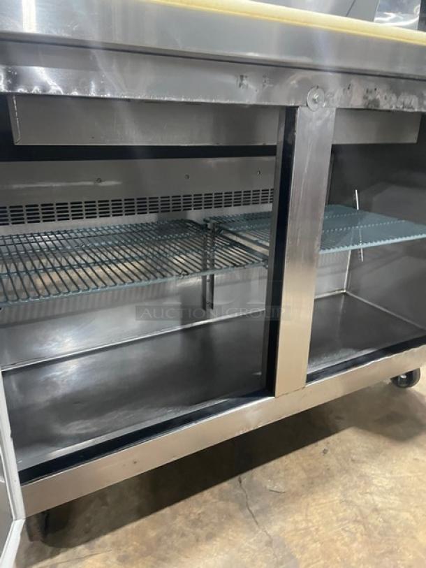 Dukers DSP48 refrigerated prep table, stainless steel, 2-door, with cutting board, poly-coated rack, on casters.