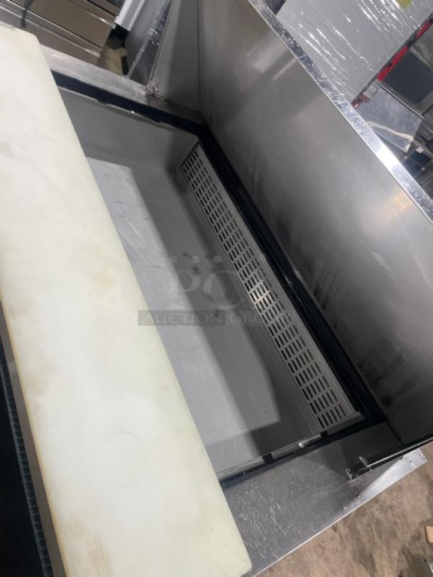 Dukers DSP48 stainless steel 2-door refrigerated prep table with cutting board, poly coated rack, and casters.