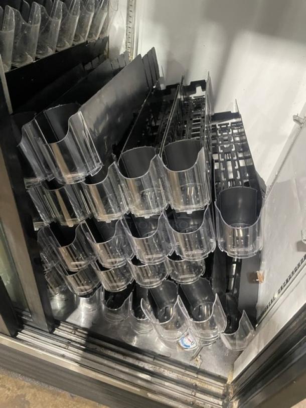 True GDM-41 commercial merchandiser refrigerator with black double glass sliding doors, pusher glide bottle organizer.