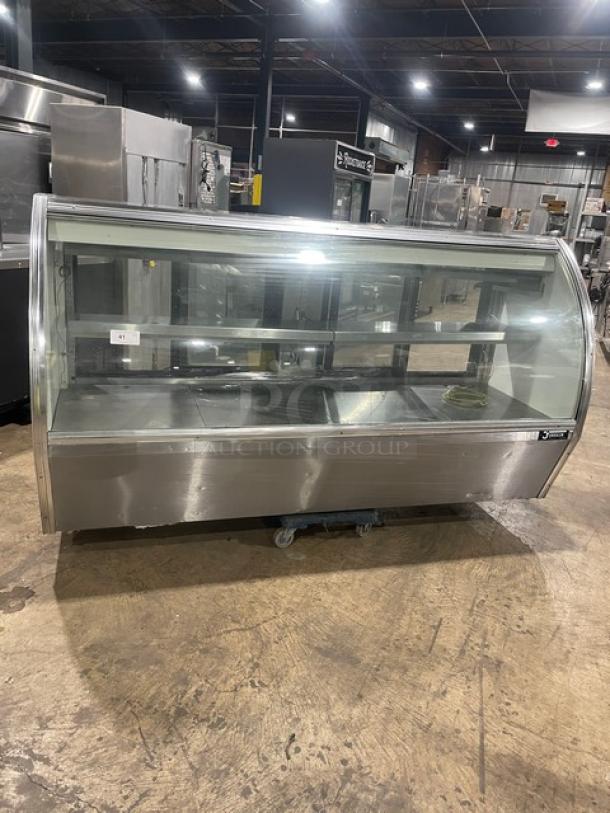 Commercial stainless steel curved glass multi-tier refrigerated bakery display case with rear access sliding glass doors in good condition.