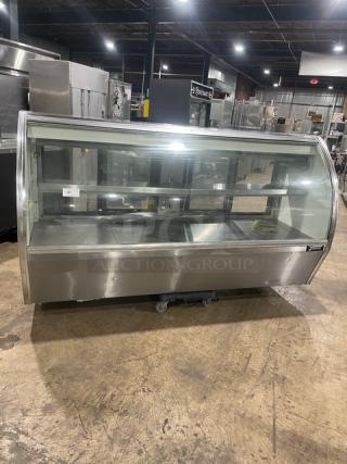 Commercial stainless steel curved glass multi-tier refrigerated bakery display case with rear access sliding glass doors in good condition.