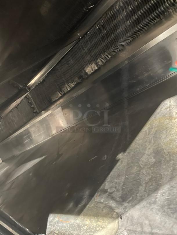 Commercial stainless steel refrigerated bakery display case with curved glass, multi-tier shelves, and rear sliding doors.