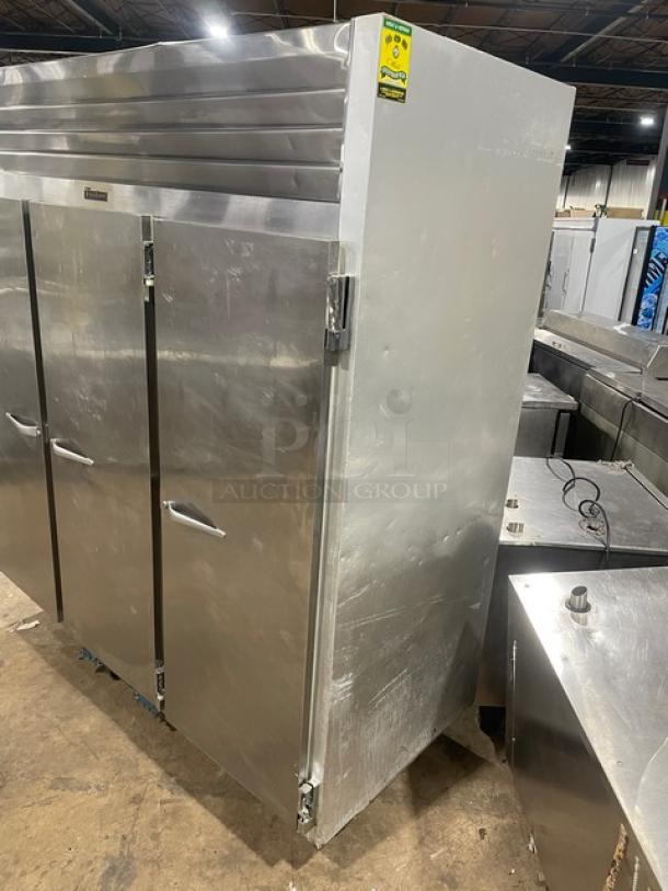 Traulsen commercial stainless steel triple door freezer, Model G31010, with poly-coated wired rack, on casters.
