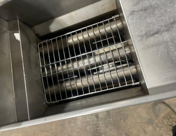 Trialator commercial stainless steel 40lb gas fryer with backsplash, on legs. Features visible burners and grill rack. Good condition.