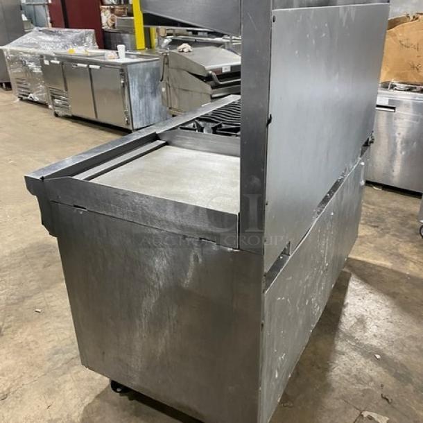 Southbend commercial stainless steel 6-burner gas range with raised 24" flat griddle, double oven, and overhead salamander shelf.