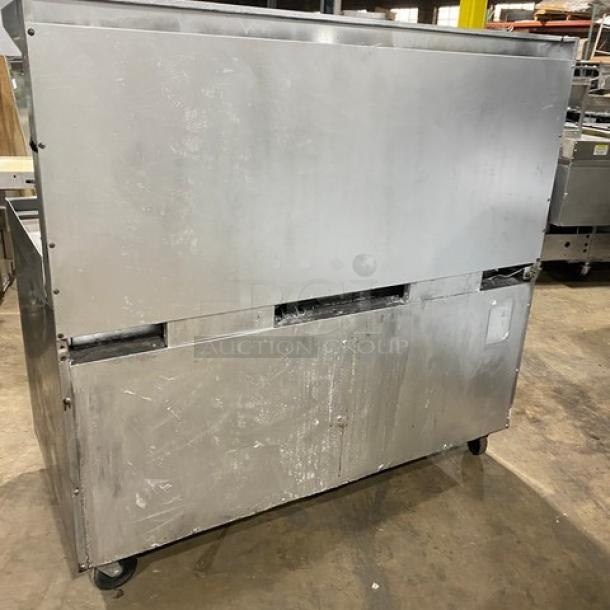 Southbend commercial stainless steel gas 6-burner range with raised 24" flat griddle, double oven, and salamander shelf. On casters.