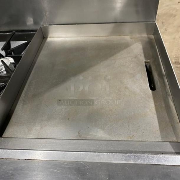 Southbend stainless steel gas range with 6 burners, 24" flat griddle, double oven, backsplash, salamander shelf, and casters.