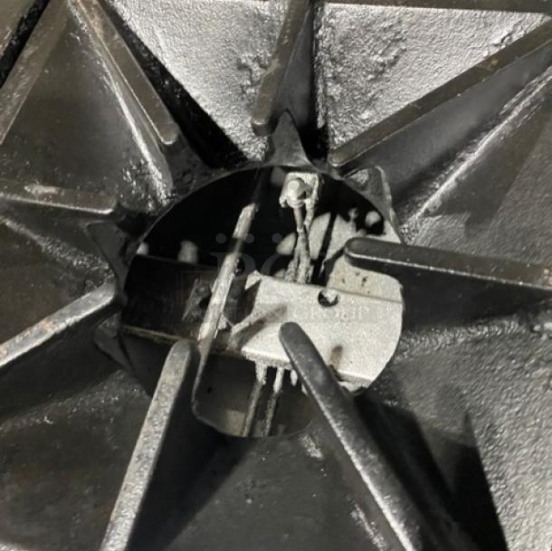 Close-up of a burner on a Southbend commercial stainless steel gas range. Features include a durable cast iron grate.