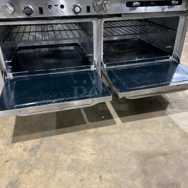 Southbend stainless steel gas range, 6 burners, dual oven with racks, 24" griddle, backsplash, salamander shelf, on casters.