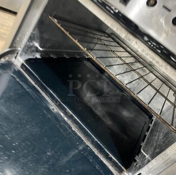 Southbend Commercial Stainless Steel Gas Range with 6 burners, raised 24" griddle, double oven, backsplash, and salamander shelf.