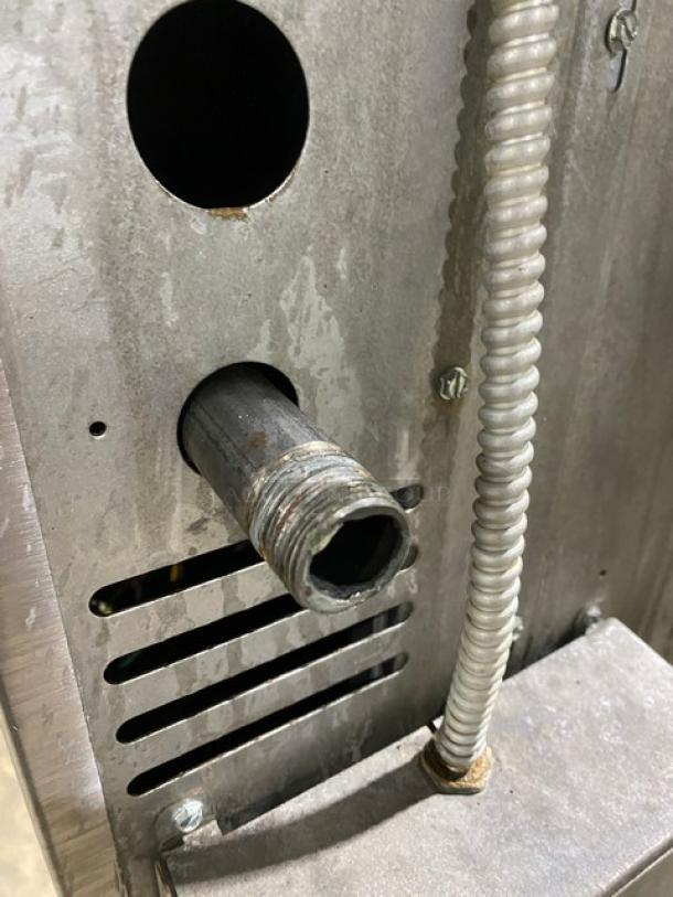 American Range stainless steel gas convection oven with a visible exhaust pipe, wiring, and vent holes.