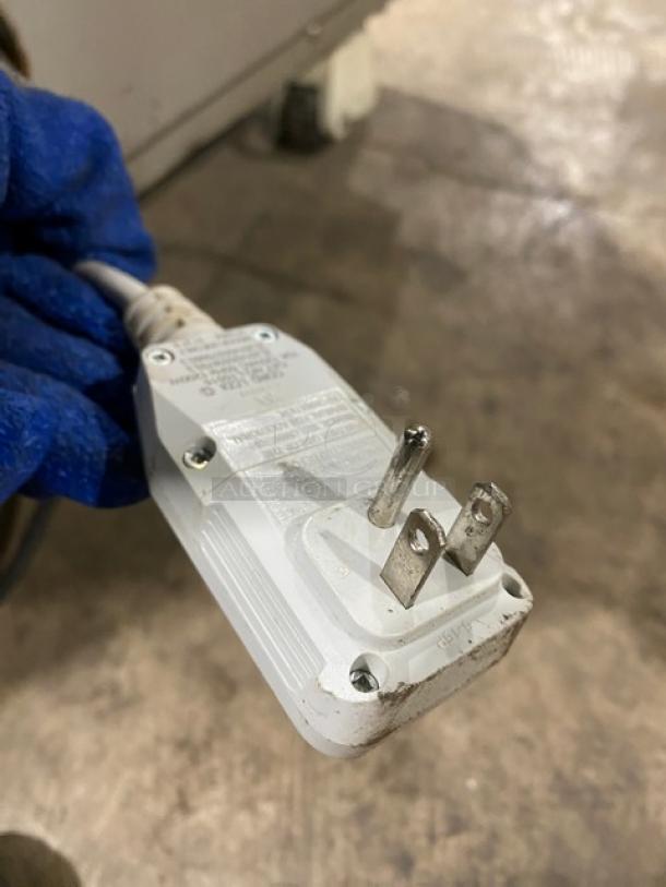 Close-up of a 120V plug for the Totally Green ORCA Series OG25 food waste digester. Plug shows some wear.