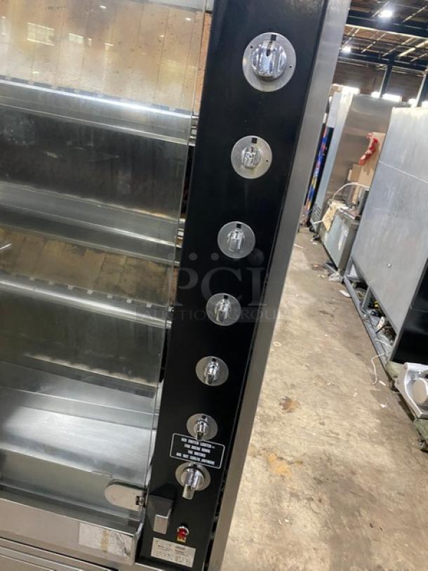 Rotisol 9505 commercial stainless steel rotisserie oven with tempered glass doors, retractable workstation, and caster base.