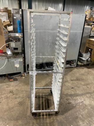 Commercial stainless steel sheet pan rack on casters, used condition, multiple slots for pans, tag number 63 visible.