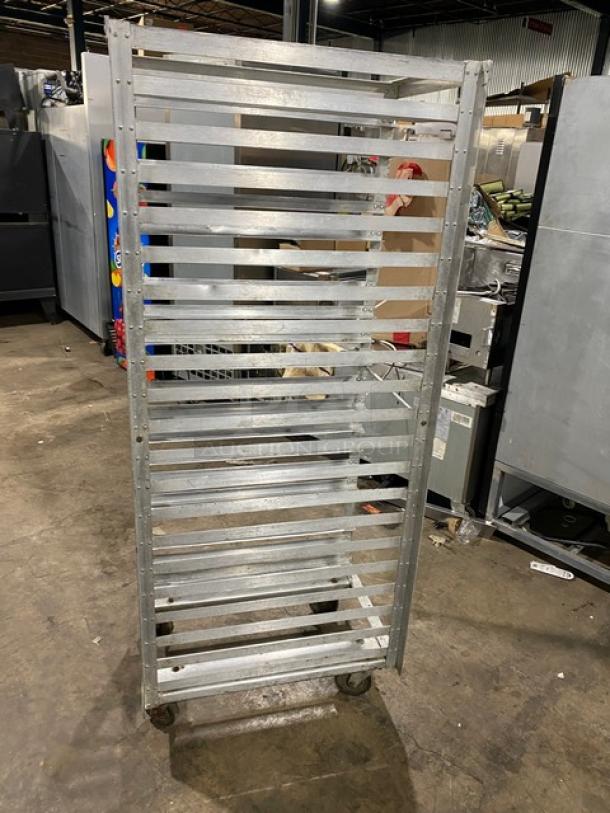Commercial stainless steel sheet pan rack on casters, featuring multiple shelves, industrial condition, ideal for bakery use.