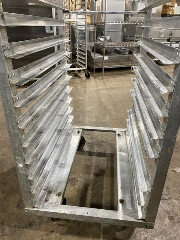 Commercial stainless steel sheet pan rack on casters, multiple slot levels, sturdy, used condition, ideal for kitchens.